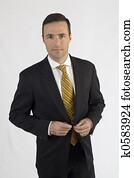 Handsome man in black suit buttoning jacket