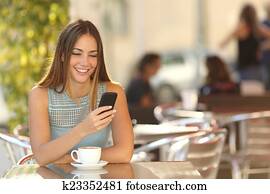 Girl texting on the phone in a restaurant Girl texting on the phone in a restaurant