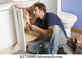Plumber working on sink Plumber working on sink