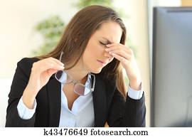 Businesswoman suffering eyestrain at office