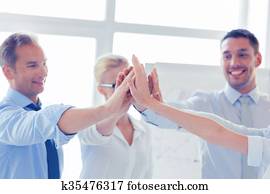happy business team giving high five in office