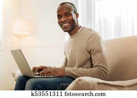 Smiling man working on the laptop