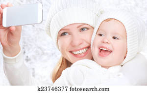 selfie  in winter. happy family mother with daughter and photographed self on  mobile phone