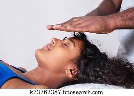Woman Having Reiki Healing Treatment Woman Having Reiki Healing Treatment