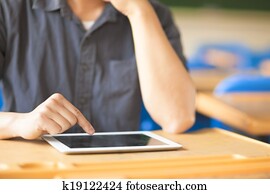 young man using a tablet or ipad in a classroom young man using a tablet or ipad in a classroom