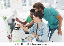 Three artists working on computer at office