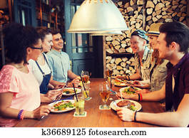 happy friends eating and drinking at bar or pub happy friends eating and drinking at bar or pub