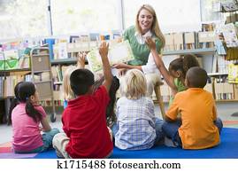 Students in class volunteering for teacher Students in class volunteering for teacher