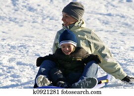 Happy Mother and Son Sledding down the Hill Happy Mother and Son Sledding down the Hill