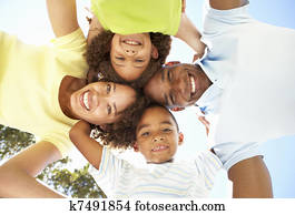 Portrait of Happy Family Looking Down Into Camera In Park
