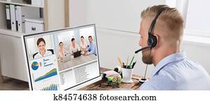 Businessman Video Conferencing With Team On Computer Businessman Video Conferencing With Team On Computer