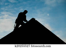 Contractor in Silhouette working on a Roof Top Contractor in Silhouette working on a Roof Top