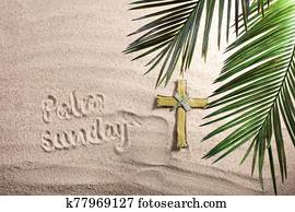 Cross and Palm Tree Leaves on sand. Palm sunday concept. Top view