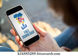 woman sitting in the street holding her smartphone showing free download woman sitting in the street holding her smartphone showing free download
