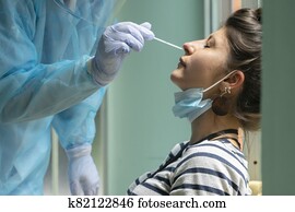 Healthcare worker with protective equipment performs coronavirus swab on Caucasian girl. Healthcare worker with protective equipment performs coronavirus swab on Caucasian girl.
