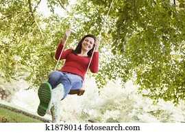 Young woman on tree swing