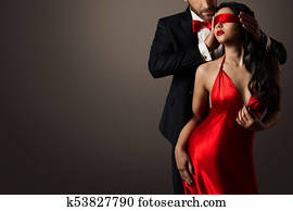 Couple Love Kiss, Blindfolded Woman Dancing in Red Dress and Elegant Man in Suit Couple Love Kiss, Blindfolded Woman Dancing in Red Dress and Elegant Man in Suit