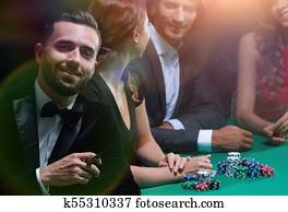 Man with cigar looking up from poker game in casino