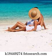 Couple in white relax on a beach at Maldives