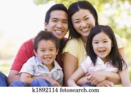 Family sitting outdoors smiling Family sitting outdoors smiling