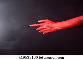 Red devil pointing hand with black sharp nails, extreme body-art, Halloween theme Red devil pointing hand with black sharp nails, extreme body-art, Halloween theme