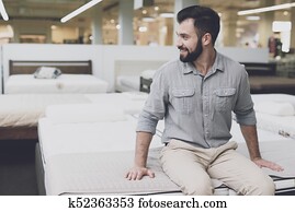 a, homme, dans, a, grand, magasin, chooses, a, matelas, pour, himself., il, est assis, sur, lui, à, essayer, il, dehors