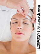 Hand waxing beautiful woman's eyebrow Hand waxing beautiful woman's eyebrow