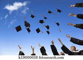 Students throwing graduation hats in the air celebrating Students throwing graduation hats in the air celebrating