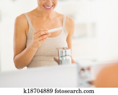 Closeup on happy young woman with pregnancy test