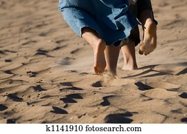 Barefoot legs on the sand beach