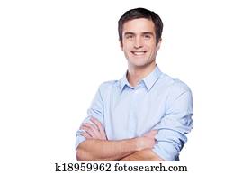 Confident businessman. Portrait of handsome young man in blue shirt looking at camera and keeping arms crossed while standing isolated on white