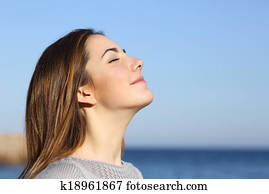 Woman portrait breathing deep fresh air on the beach