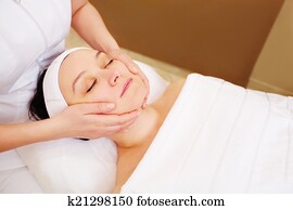 Woman taking facial treatments at beauty spa