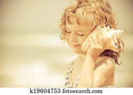 Happy child listen to seashell at the beach Happy child listen to seashell at the beach
