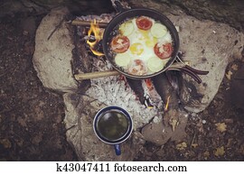 Cooking breakfast on a campfire at a summer camp. Cooking breakfast on a campfire at a summer camp.