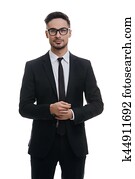 Portrait of style. Handsome young man in full suit adjusting his sleeve and looking at camera with smile while standing against white background