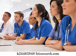 Medical students listening sitting at desk Medical students listening sitting at desk