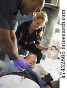 Paramedics performing CPR on patient in ambulance Paramedics performing CPR on patient in ambulance