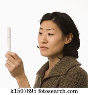 Woman holding pregnancy test.