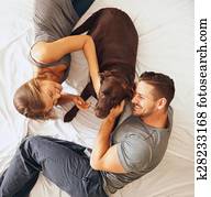 Happy young family relaxing on bed together