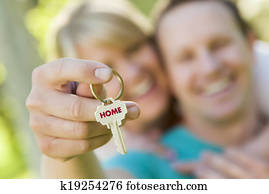 Couple Holding House Key with Home Text