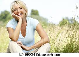 Portrait of mature woman sitting in countryside Portrait of mature woman sitting in countryside