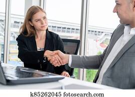 Businessman handshake businesswoman in office.