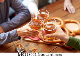 close up of hands clinking beer at bar or pub close up of hands clinking beer at bar or pub