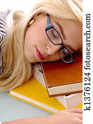 close view of female sleeping on books