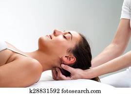 Physiotherapist pressing back of womans head. Physiotherapist pressing back of womans head.