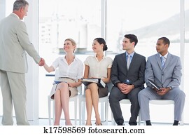 hombre de negocios, sacudarir las manos, con, mujer, besides, gente, esperar, para, entrevista de trabajo, en, un, brillante, oficina