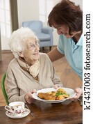 Senior Woman Being Served Meal By Carer Senior Woman Being Served Meal By Carer
