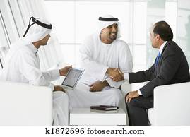 Three Middle Eastern men talking at a business meeting