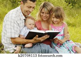 young family reading the Bible in nature young family reading the Bible in nature